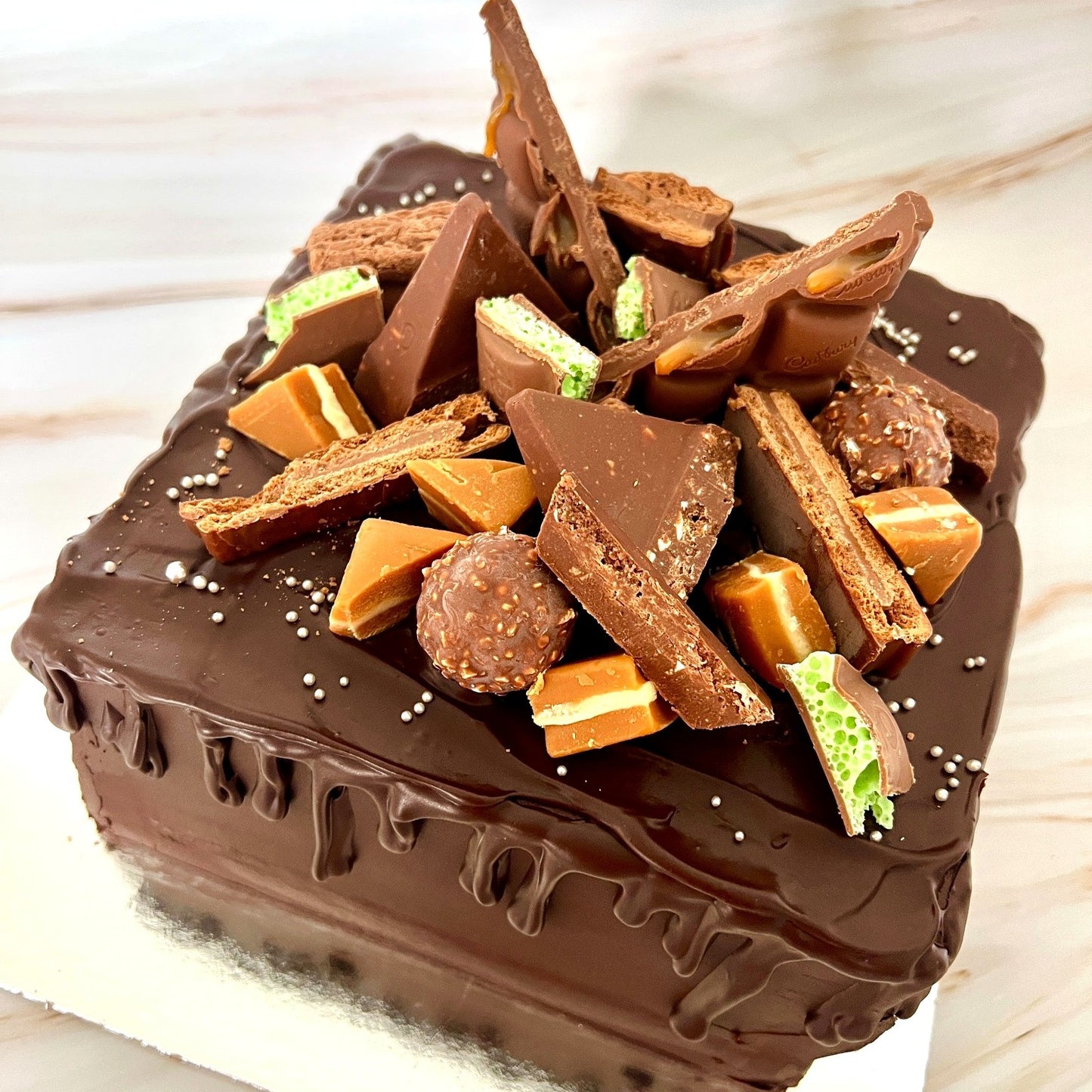 Chocolate cake with candy pieces on a wooden surface